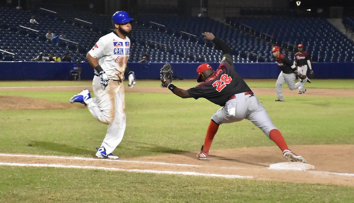 Un jugador de Caimanes intentando llegar a primera base.