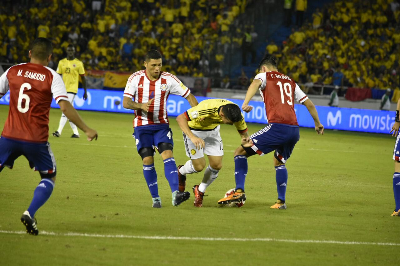 James Rodríguez intenta pasar entre Fabián Balbuena y Richard Ortiz.