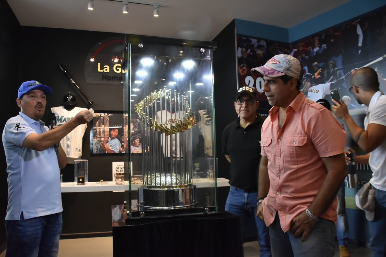 El historiador Édgar Oviedo y el Alcalde Alejandro Char muestran el trofeo que ganaron los Gigantes de San Francisco con el home run de Édgar Rentería.