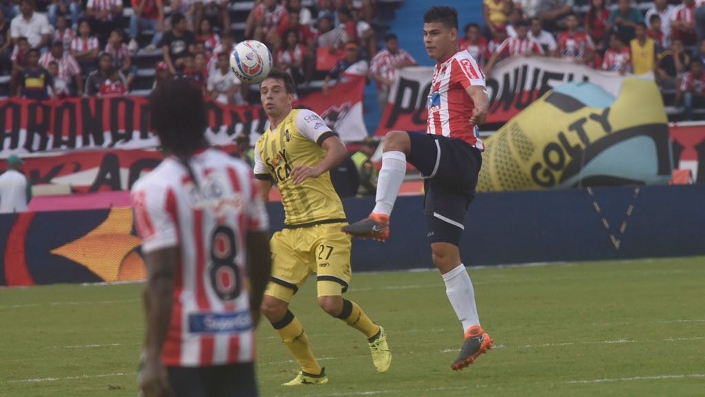 Jorge Arias rechaza el balon en una llegada de Pablo Vranjicán.