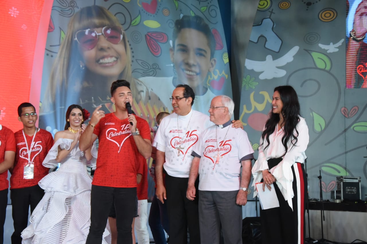 Artista canta el himno de la Catedratón a Monseñor Pablo Emiro Salas, Monseñor Tamayo y la presentadora María Patricia Dávila.