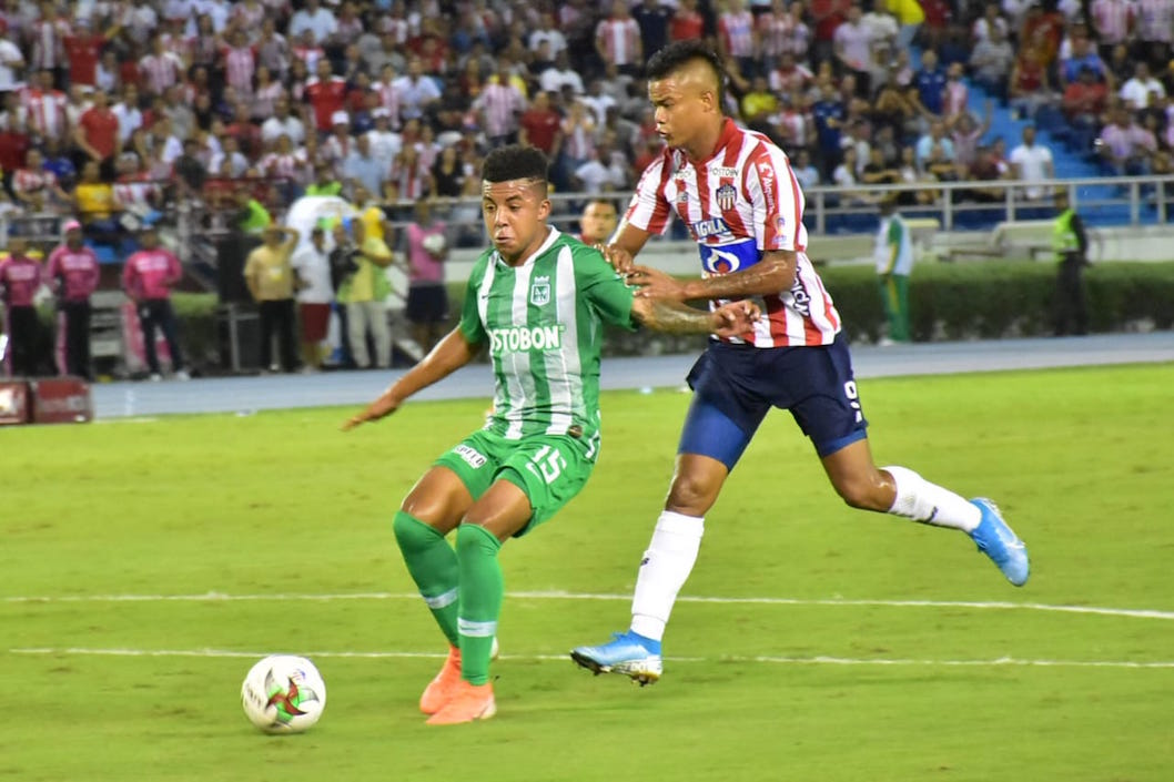 Luis 'El Chino' Sandoval disputando el balón con Cristian Blanco.