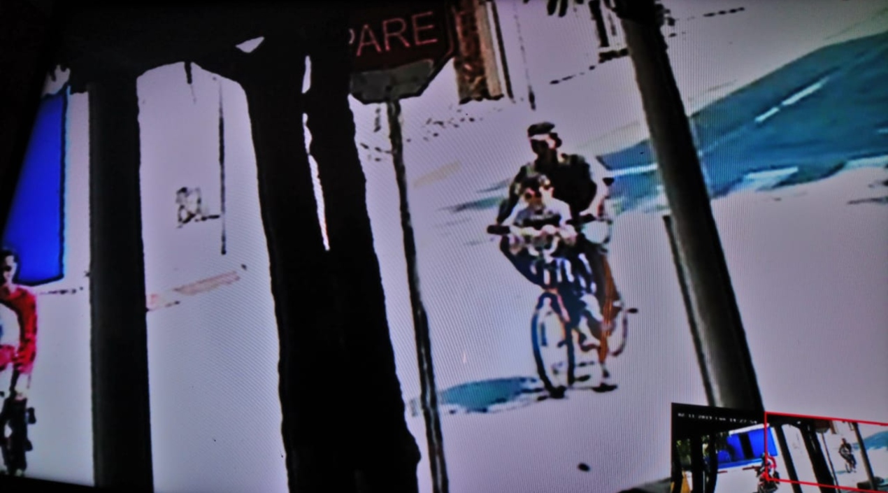 Imagen de una cámara de seguridad muestra al sujeto cuando iba en bicicleta con uno de los niños víctimas del robo.