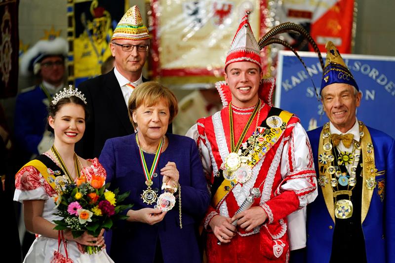  La canciller alemana Angela Merkel (2i) posa, este martes, durante la recepción a varios grupos carnavalescos en la Cancillería en Berlín.