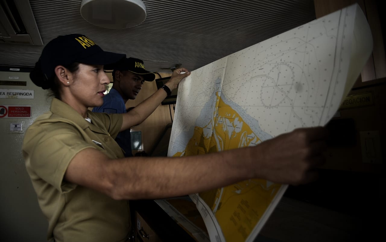 Una oficial de la tripulación mira un mapa, el primer elem