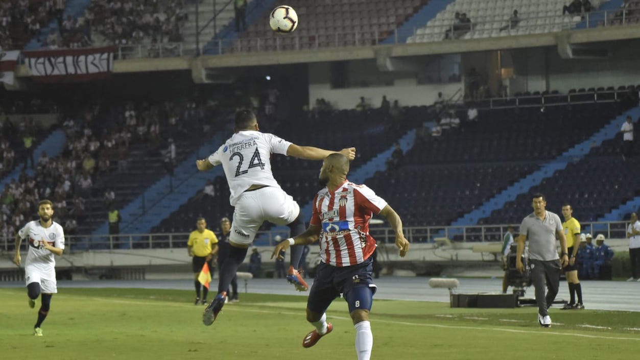 Marcelo Herrera despejando el balón ante la llegada de Freddy Hinestroza.