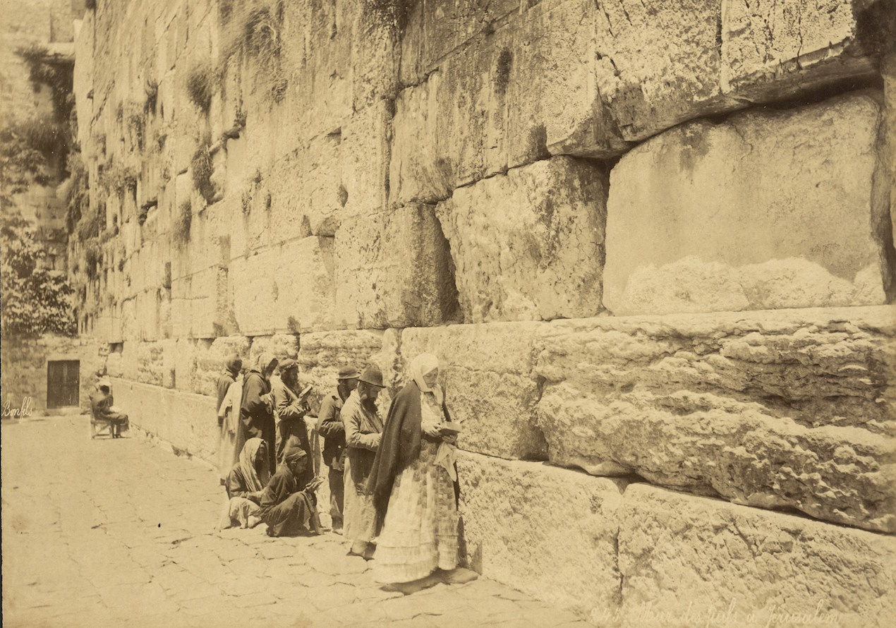 Fotografía cedida por la Biblioteca Nacional de Israel, donde aparecen personas judías rezando en el Muro Occidental, también conocido como Muro de las Lamentaciones, en la ciudad Vieja de Jerusalén, alrededor de 1880. 