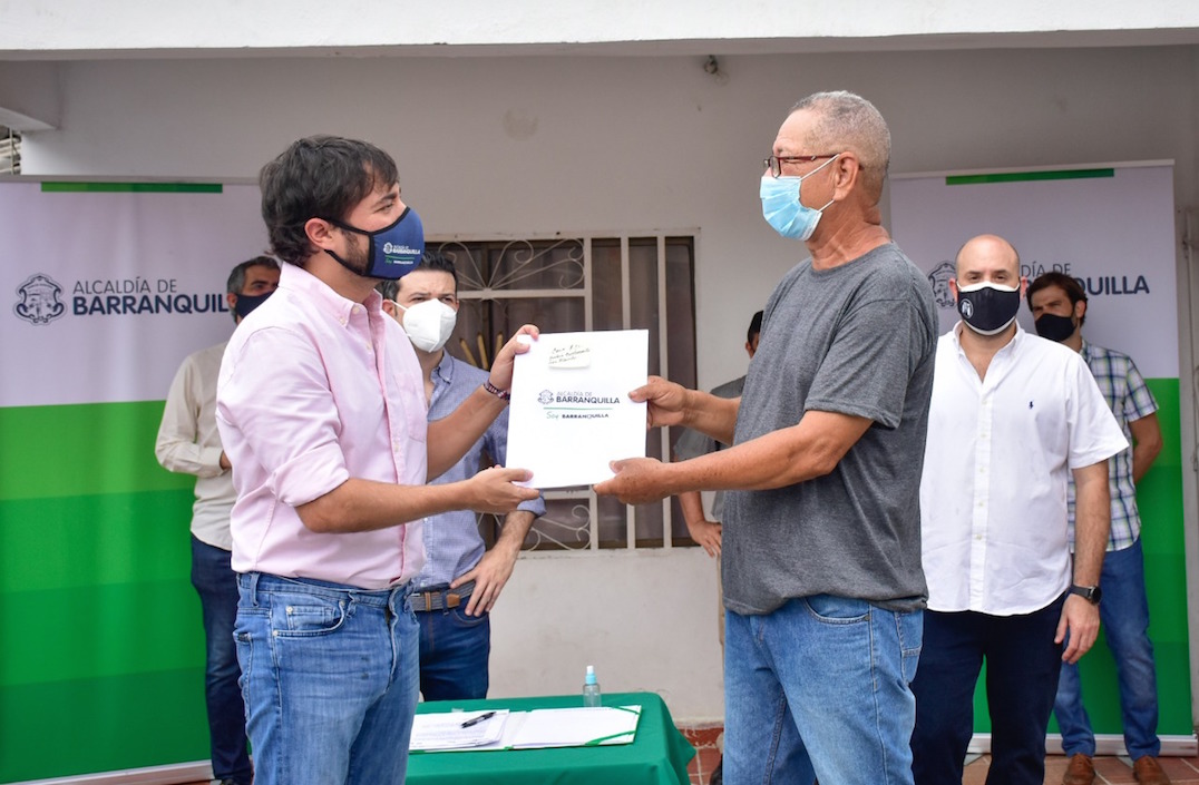 El Alcalde Jaime Pumarejo entregando un título de vivienda.
