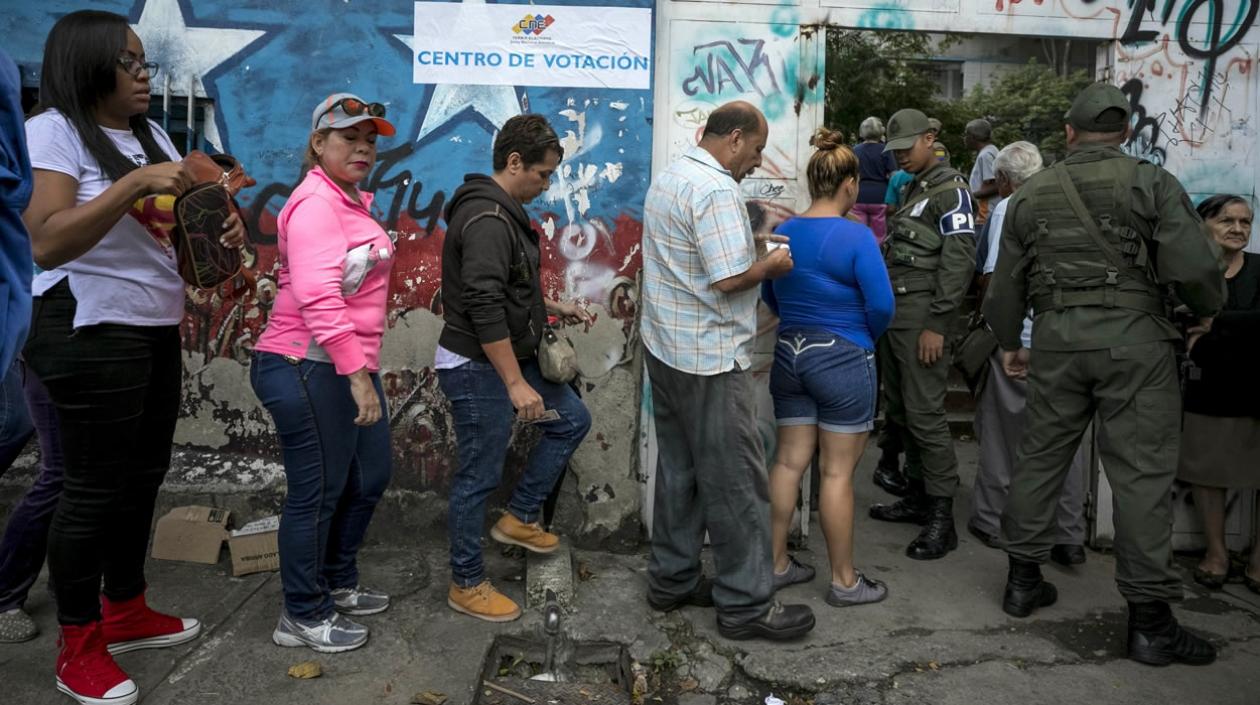 Varias personas asisten a un centro de votación en Caracas (Venezuela).