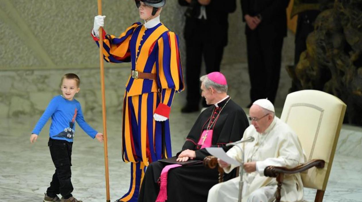 Un niño argentino de unos siete u ocho años accede al escenario del Aula Pablo VI mientras el papa Francisco (d) preside su audiencia general de los miércoles en el Vaticano, 