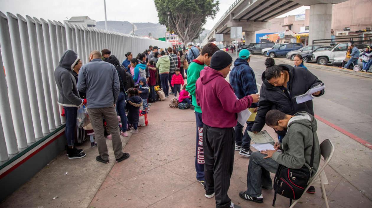 Un grupo de migrantes venezolanos, guatemaltecos, hondureños y mexicanos esperan para iniciar la solicitud de visa humanitaria 