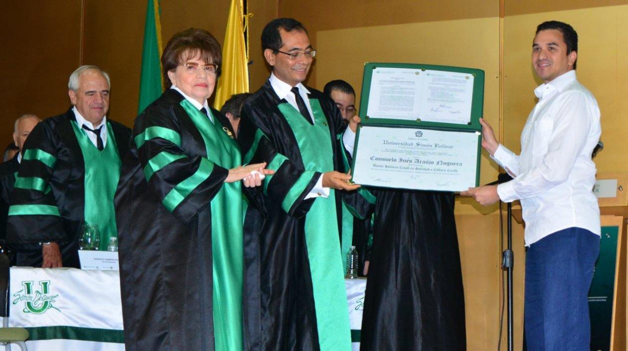 Andrés Molina recibe de manos del rector José Consuegra Bolívar el título póstumo Honoris Causa en Sociedad y Cultura Caribe para su mamá Consuelo Araújo.