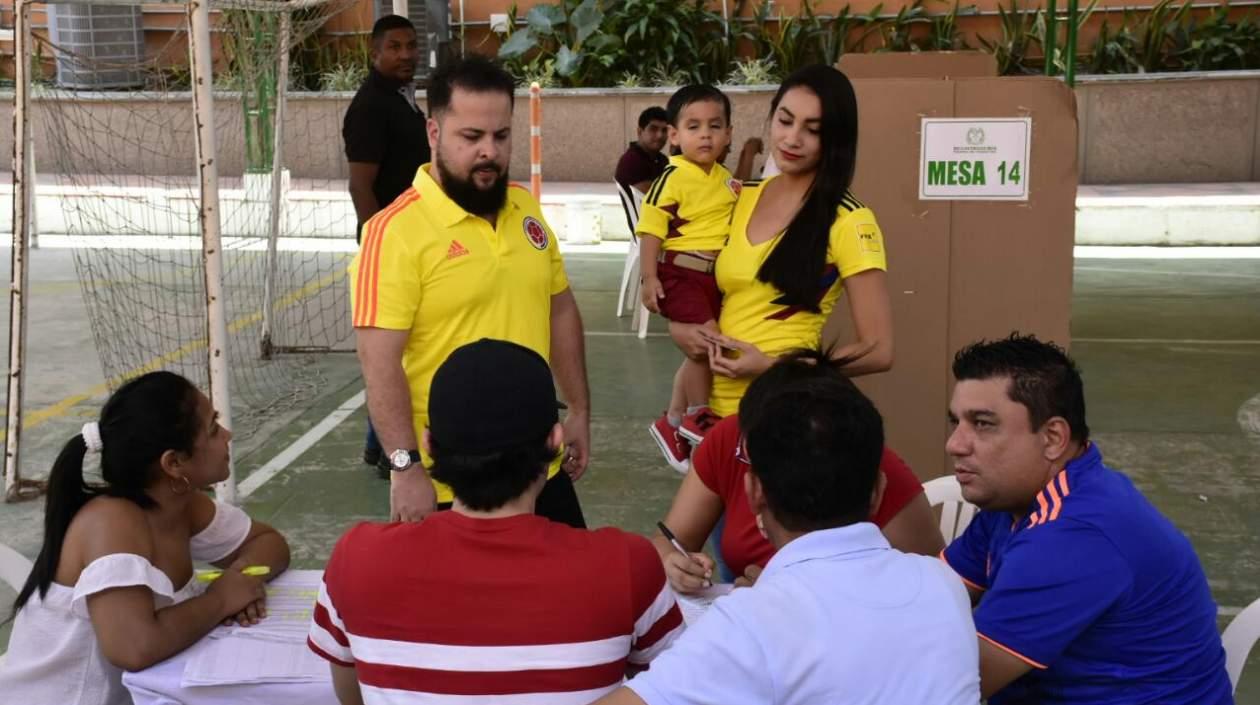 Una familia vota ataviada con los colores de la Selección Colombia.
