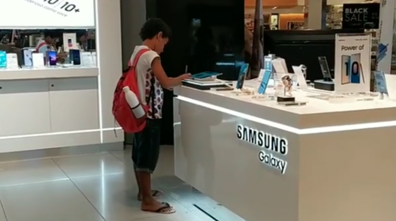 Niño haciendo su tarea en centro comercial de Brasil.