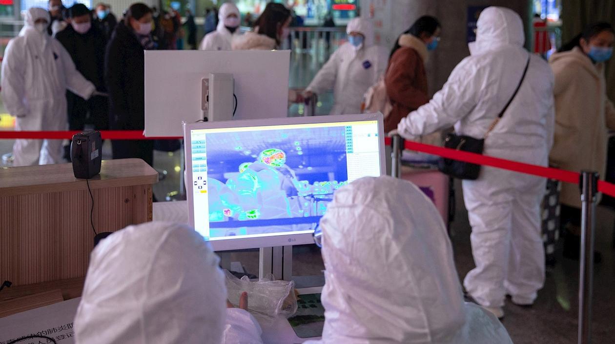 Personal médico utiliza imágenes térmicas visibles e infrarrojas para revisar la temperatura de los pasajeros, en Nanjing (China).