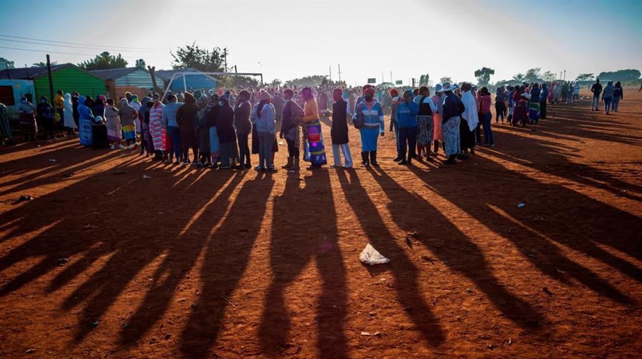 Varios ciudadanos aguardan sin distanciamiento de dos metros para recibir raciones de comida en una población de Sudáfrica. 
