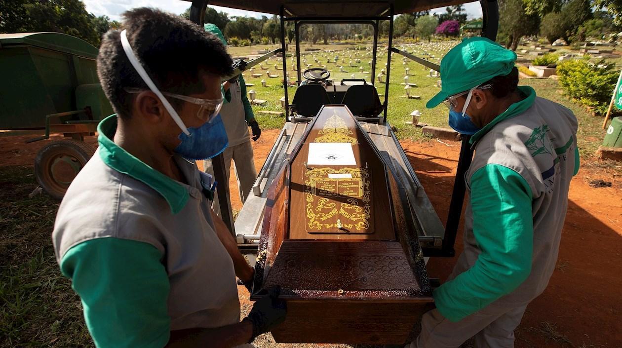 Empleados preparan a víctimas de Covid-19 para ser enterrados en el cementerio de Campo da Esperança, en Brasilia (Brasil). 