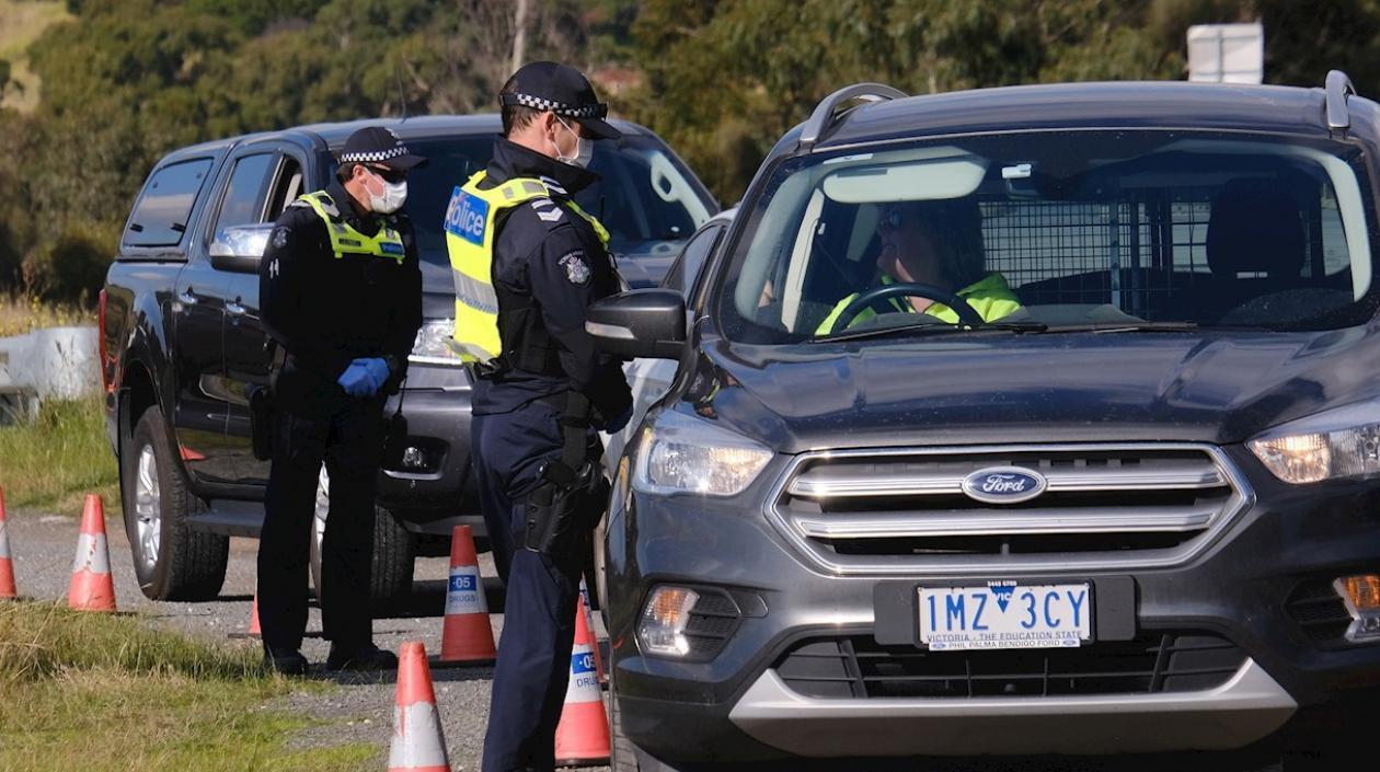 La Policía de Victoria revisa documentos de un conductor en un control cerca de Gisborne, Australia.