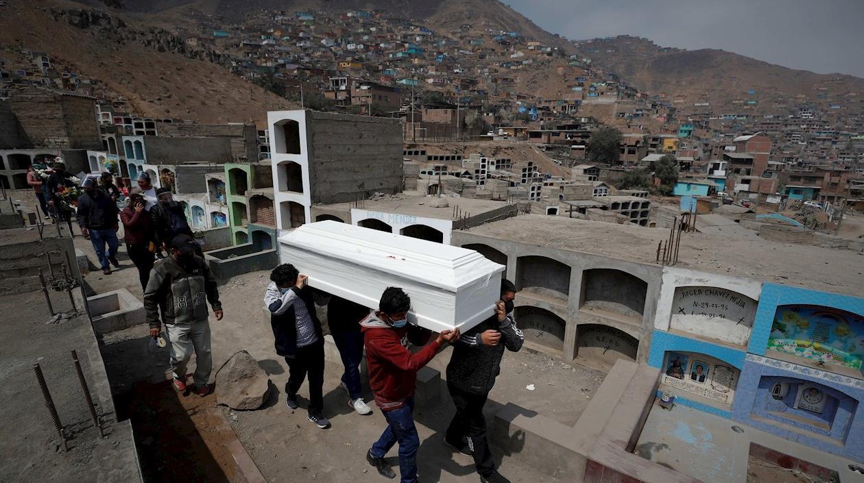 Familiares cargan el féretro de Kelly Cozme durante su entierro en el Cementerio del distrito de Comas, en Lima (Perú).