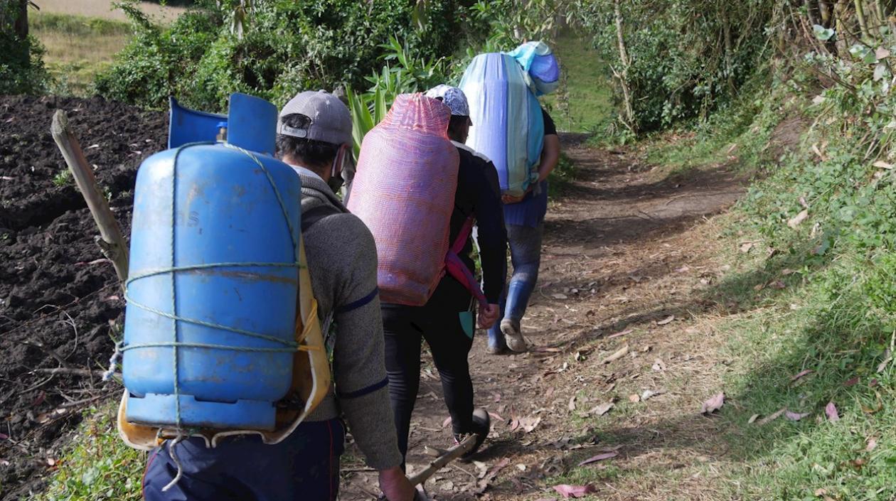 Lorena Erazo, su padre y su hermana cargan con pimpinas de gas, por una trocha entre Tulcán (Ecuador), y la localidad colombiana de Ipiales. 