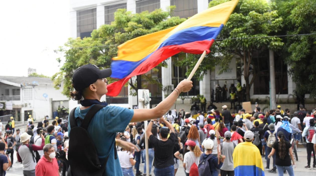 Manifestantes agitando la bandera de Colombia.