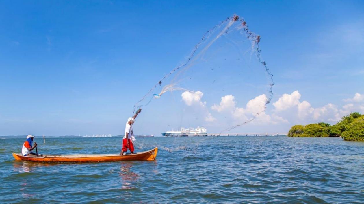 La perfecta armonía: la terminal y un pescador con su red lanzada y sostenida en el aire.