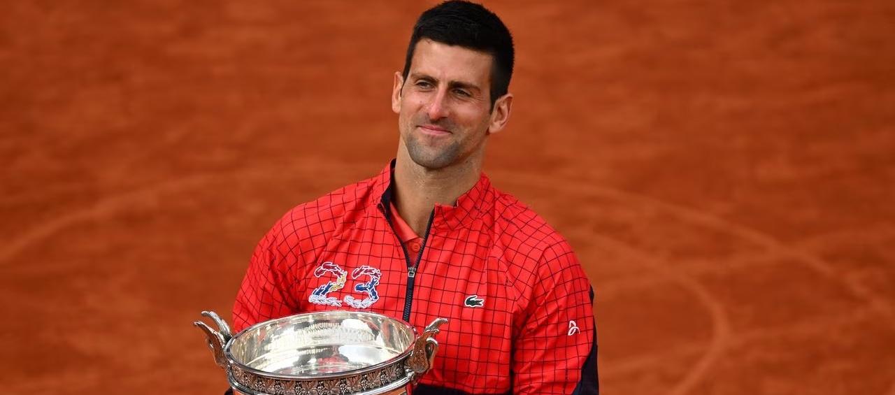Novak Djokovic besa el trofeo que lo convierte en el más ganador de torneos de Grand Slam. 
