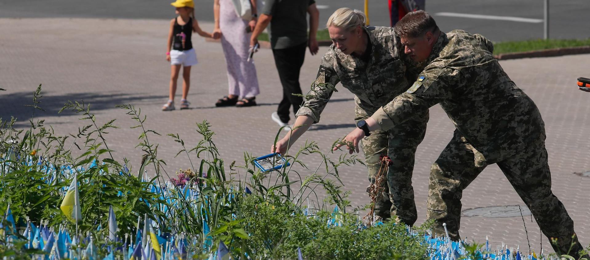 Militares ucranianos colocan un retrato de un camarada caído en la Plaza de la Independencia.