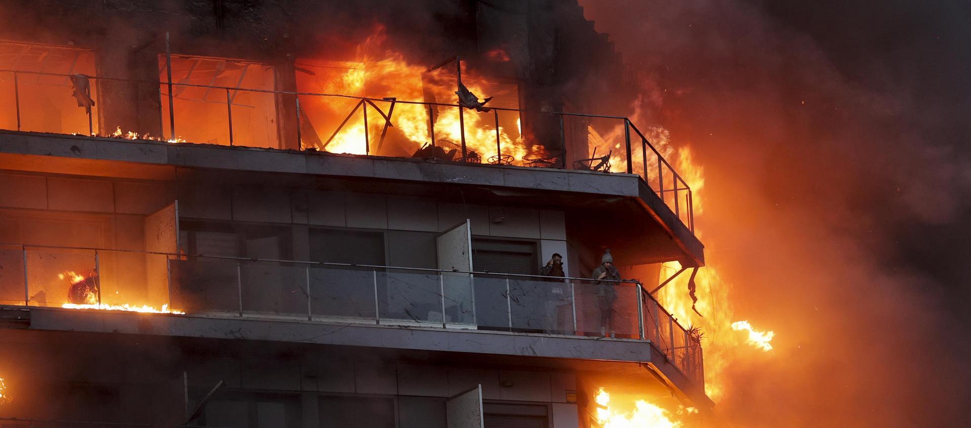 Dos personas esperan ser rescatadas del edificio en llamas en Valencia, España. 