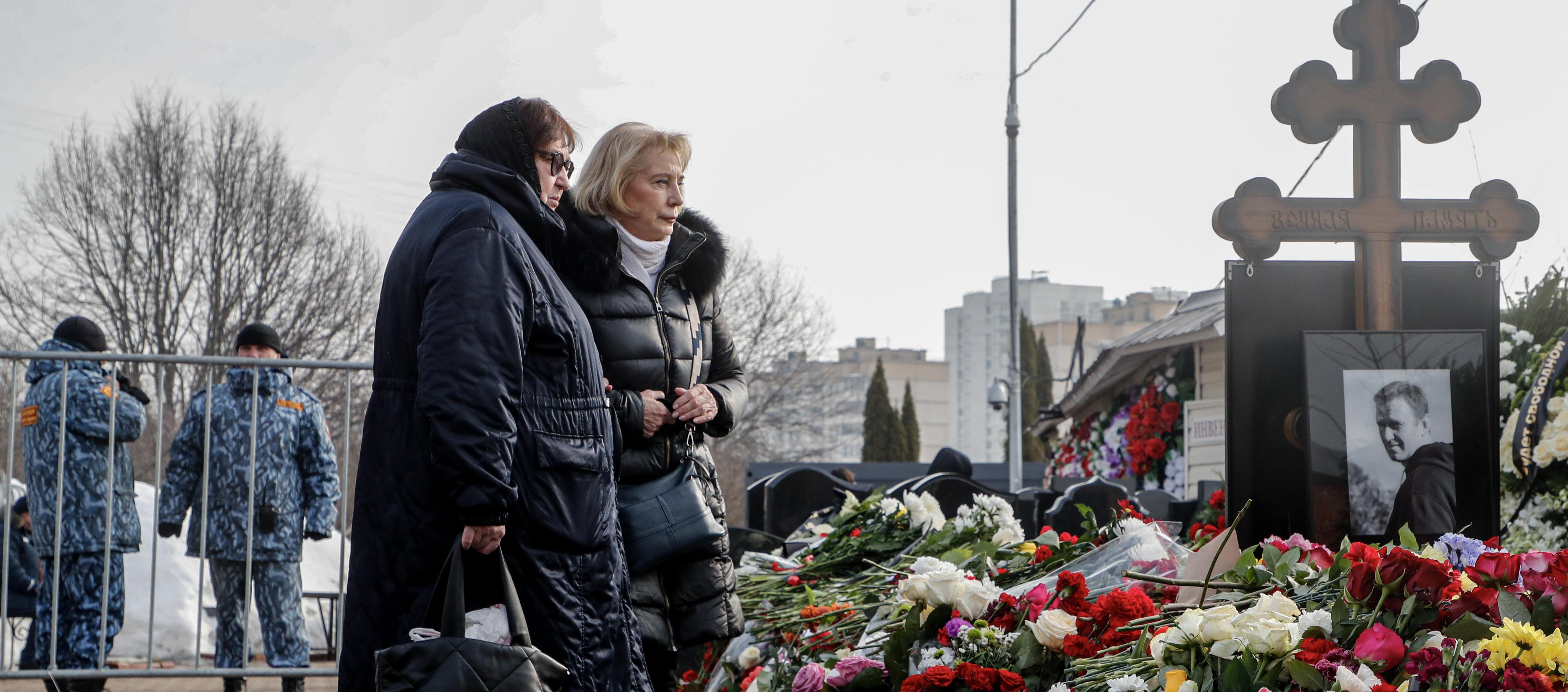 Lyudmila Navalnaya (i), madre de Alexei Navalni, ante la tumba de su hijo.