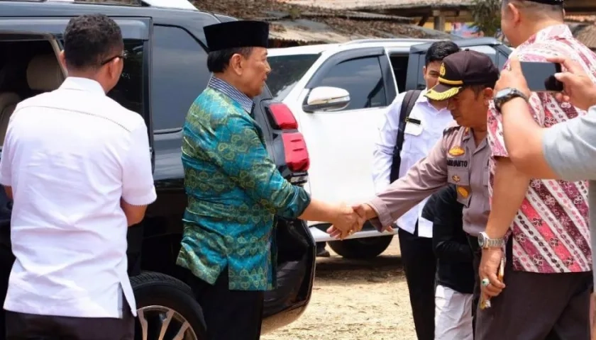 El ministro de seguridad indonesio Wiranto (de verde) es recibido por un oficial local poco antes de ser atacado por un hombre con un cuchillo.