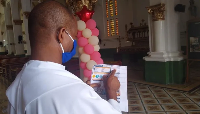 El sacerdote Roberto Rodríguez Padilla, párroco de la Iglesia de Chiquinquirá, muestra el recibo.