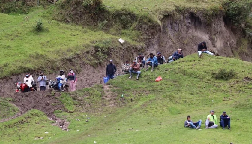 Migrantes venezolanos descansan en una de las colinas junto al cauce del fronterizo río Carchi.
