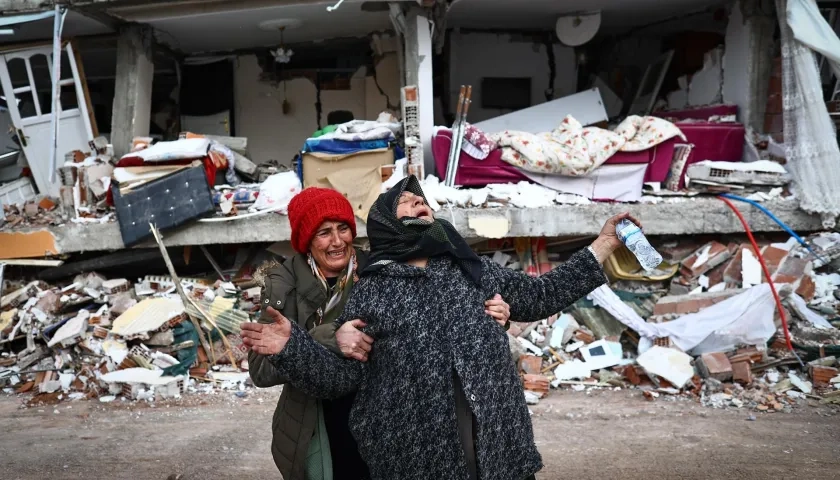 Dos mujeres lloran junto a un edificio derrumbado tras el gran terremoto en el distrito de Elbistan de Kahramanmaras.
