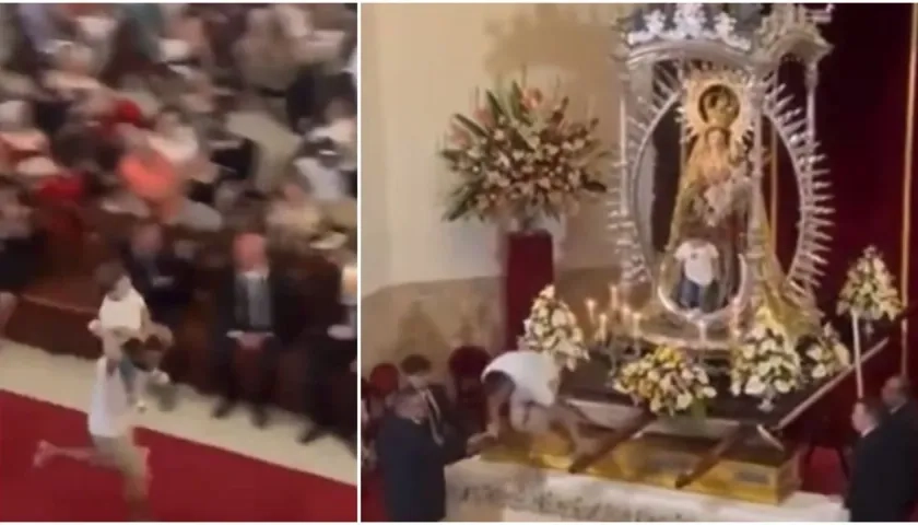 Hombre intenta sentar a su hijo al lado de la Virgen del Carmen. 