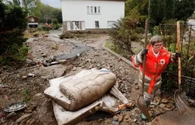 Una voluntaria de la Cruz Roja despeja una calle de escombros tras las inundaciones provocadas por las fuertes lluvias en el departamento de Aude, en Conques (Francia).
