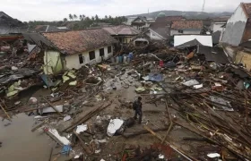 Los residentes locales caminan entre los escombros después de que un tsunami golpeó el Estrecho de Sunda en Sumur, Banten