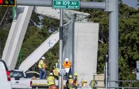 Obreros trabajando en la estructura caída del puente peatonal en Miami. 