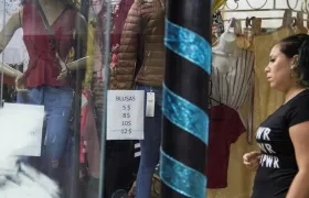 Una mujer mira los precios en dólar en una tienda.