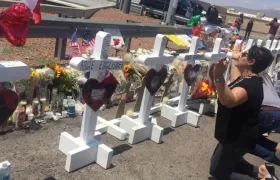 Una señora ora junto a las cruces que fueron colocadas frente a la tienda Walmart en El Paso, Texas, lugar donde ocurrió una masacre.