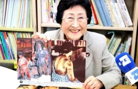 La superviviente de la bomba atómica de Hiroshima, Michiko Kodama sonríe mientras muestra una lámina que representa los efectos de la explosión de la bomba atómica.