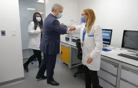 El presidente Iván Duque saluda a una de las funcionarios del laboratorio antidojape. 