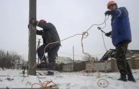 Imagen de archivo de dos operarios trabajando en el tendido eléctrico de la ciudad de Avdiivka, Ucrania.