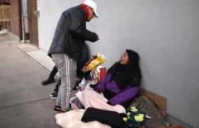 Inmigrantes indocumentados mexicanos comen en el suelo en una calle de la ciudad fronteriza de El Paso, Texas.