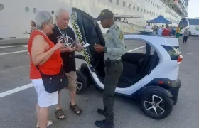 Un policía atiende a dos turistas que arribaron en un crucero a Cartagena.