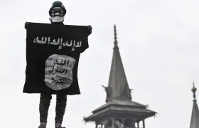 Hombre sostiene la bandera del Estado Islámico.