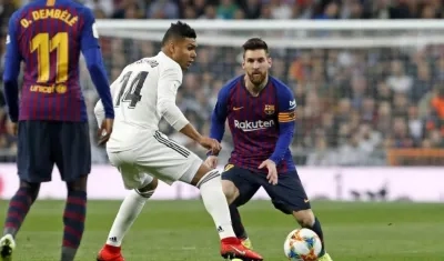 Lionel Messi y Casemiro disputan una pelota. 