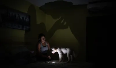 Una mujer usa la lámpara de su celular tras la falta de energía en Venezuela. 